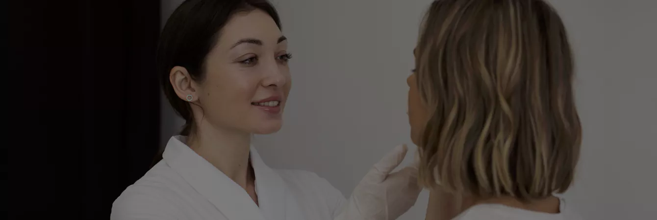 A doctor consults a patient about their facial skin condition